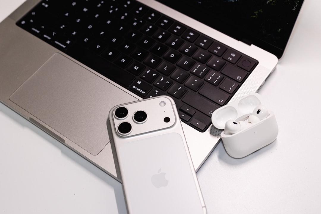 Modern wireless earbuds on desk with laptop