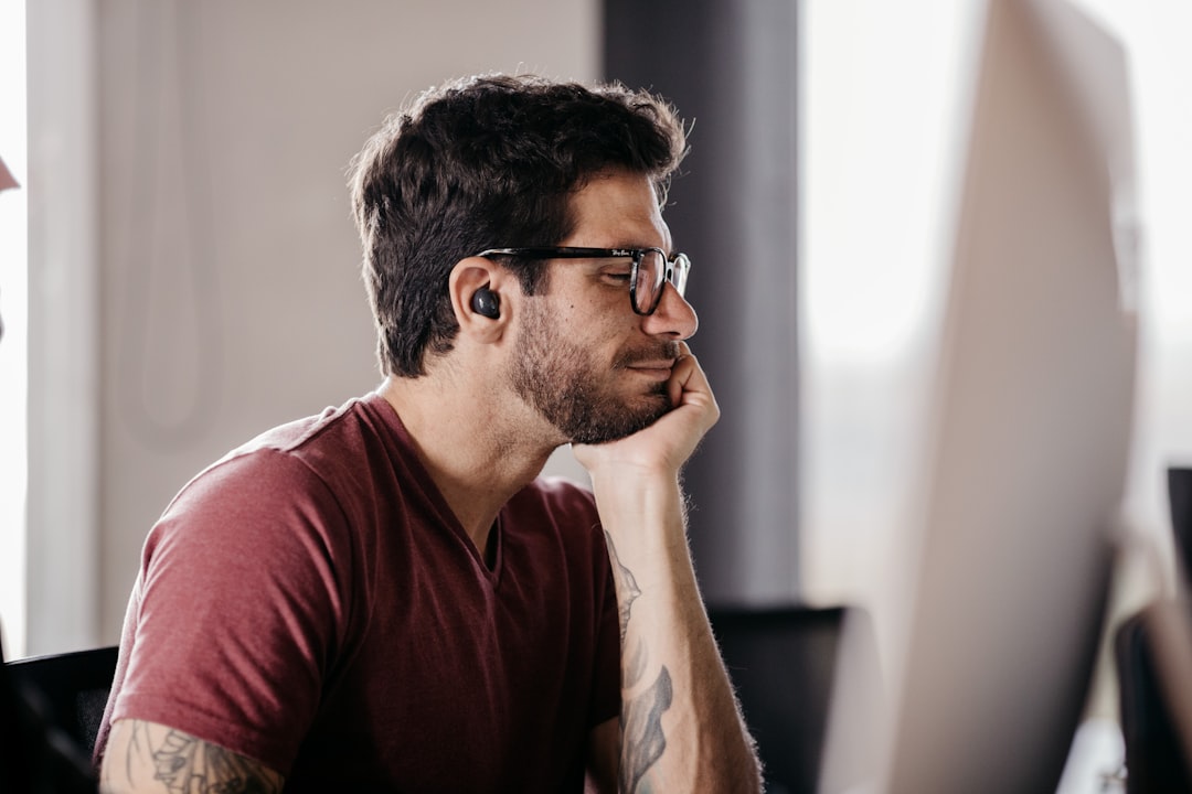 Professional worker using wireless earbuds in modern office