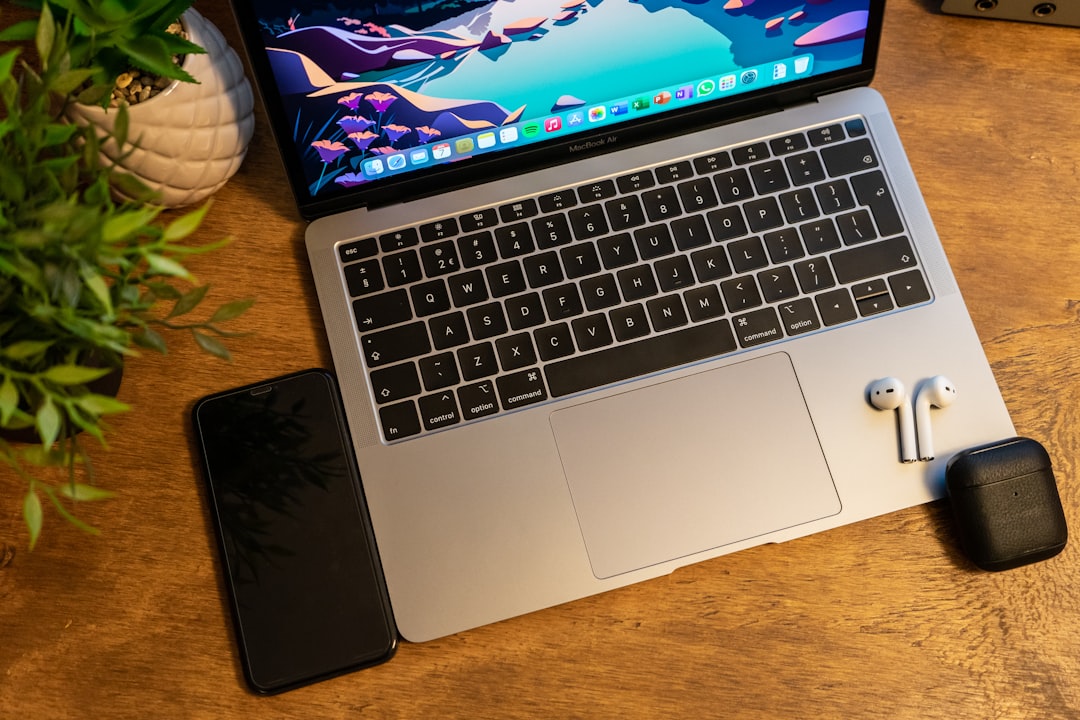 Apple AirPods with laptop on workspace