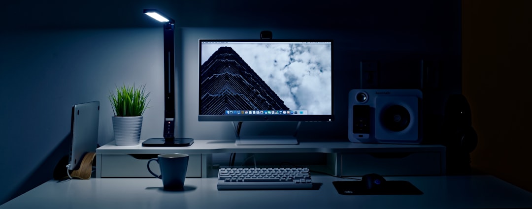Monitor light bar illuminating a workspace desk