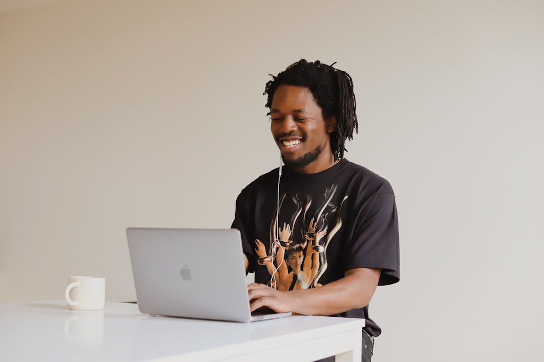 Person wearing wireless earbuds while working at a laptop