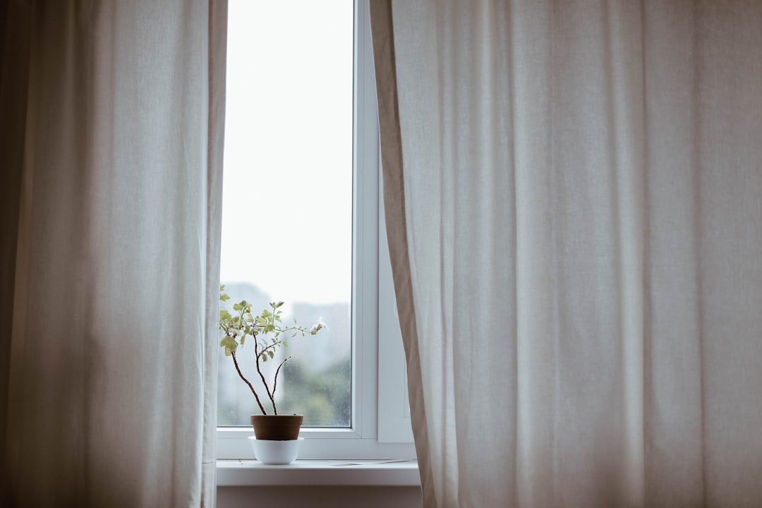 Open window with curtains flowing in a fresh breeze