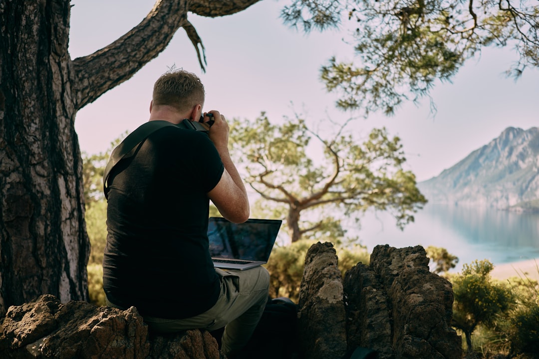 Photographer transferring photos to laptop outdoors