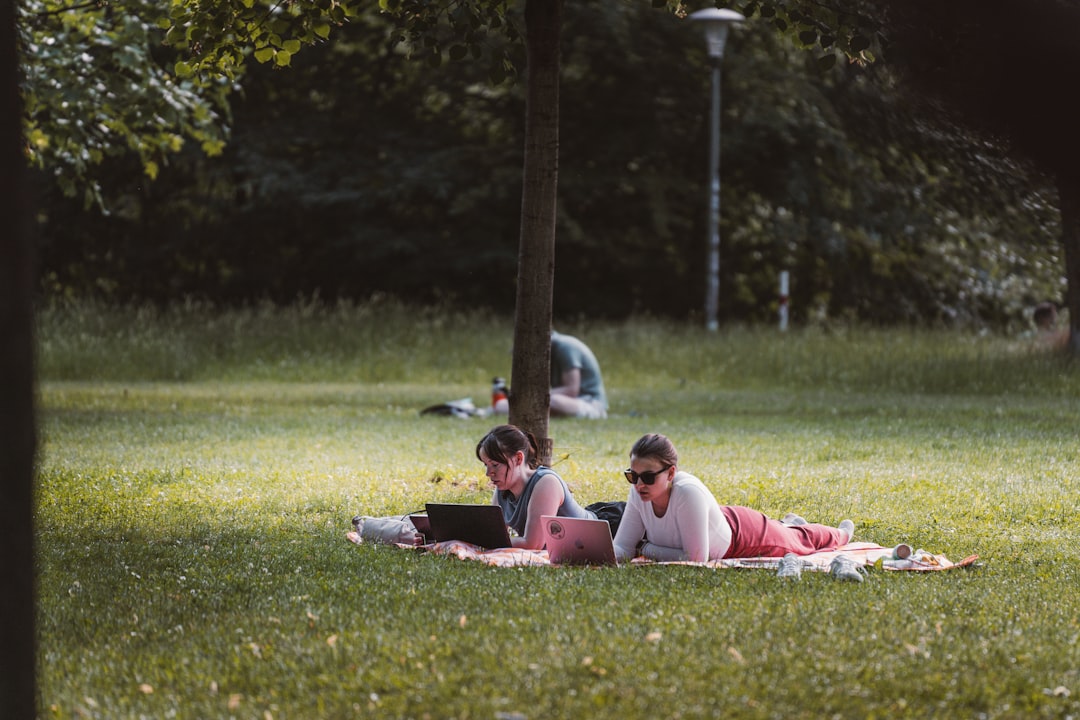 Person working on laptop outdoors in a park setting