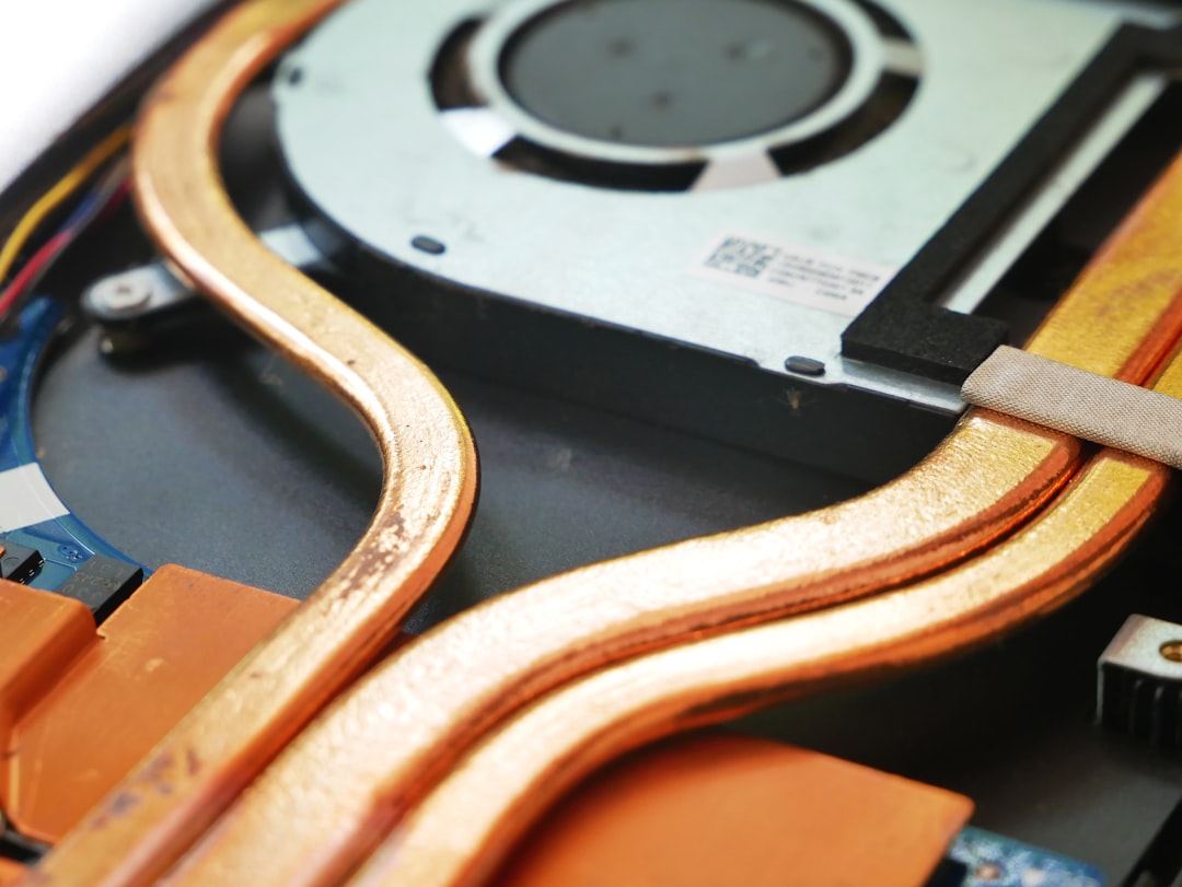 Laptop fan and heatsink being cleaned of dust