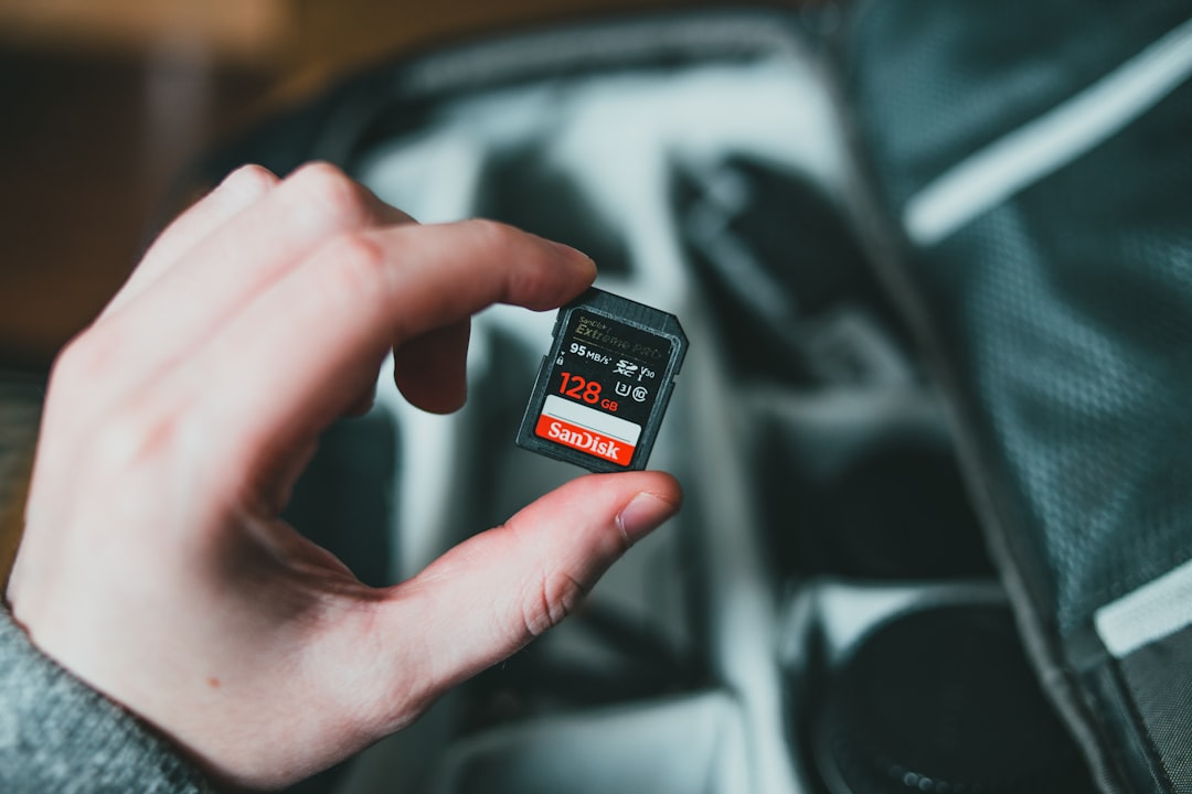 Hand holding a microSD memory card for a camera