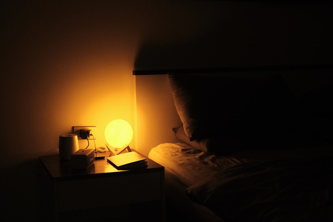 Sunrise alarm clock glowing on a bedside table in morning light