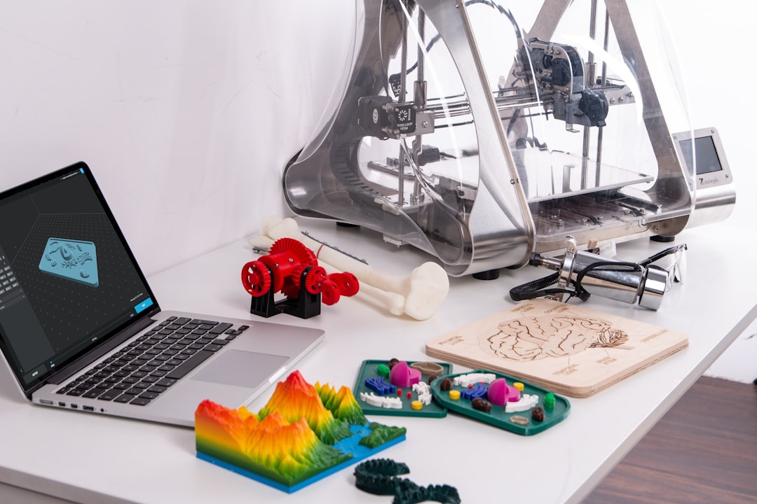 A workspace filled with colorful 3D printed objects like gears and terrain models