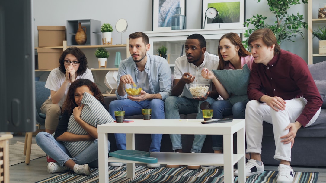 Friends watching sports together on TV with snacks