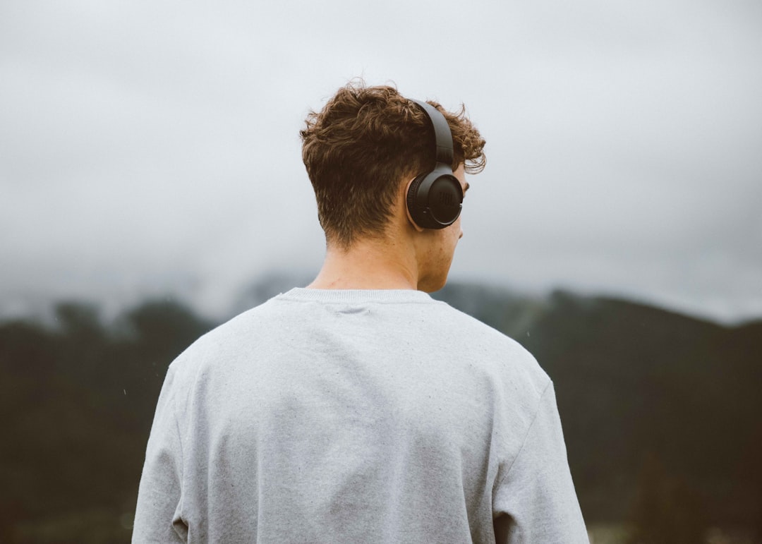 Person wearing over-ear headphones in a focused listening environment