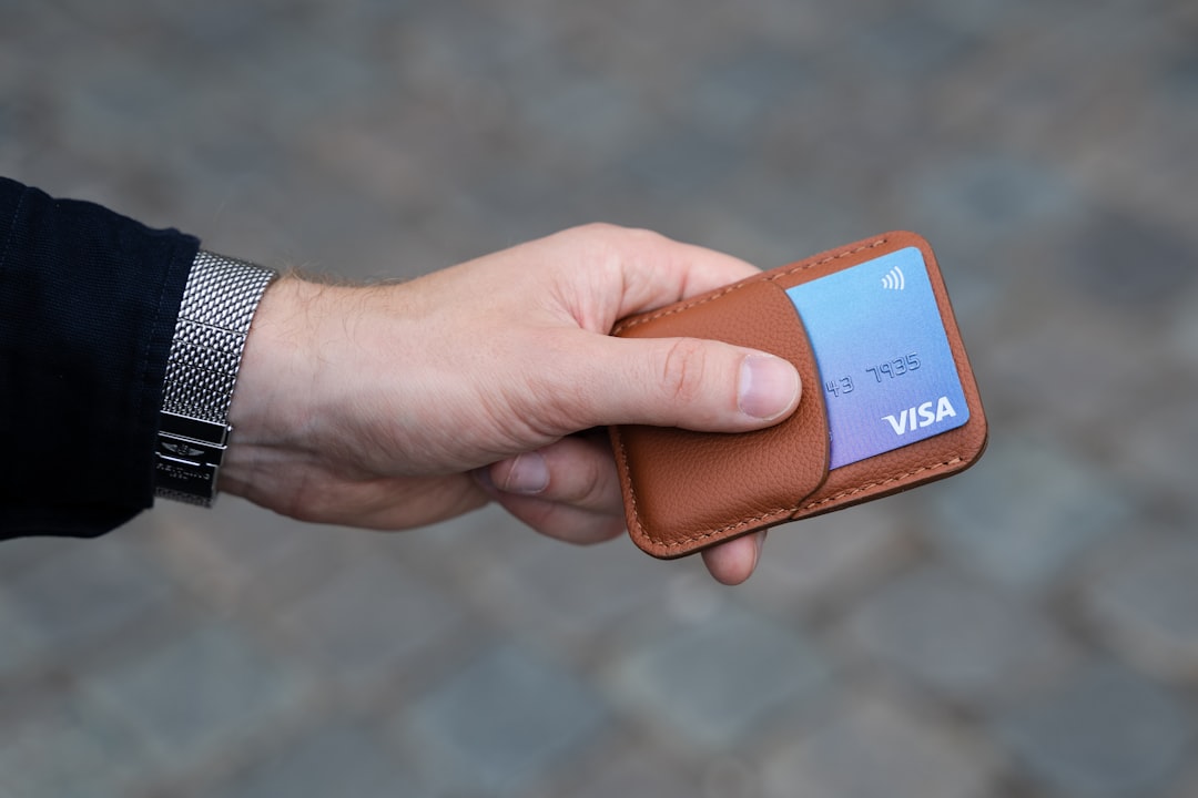 Slim brown leather wallet held in hand