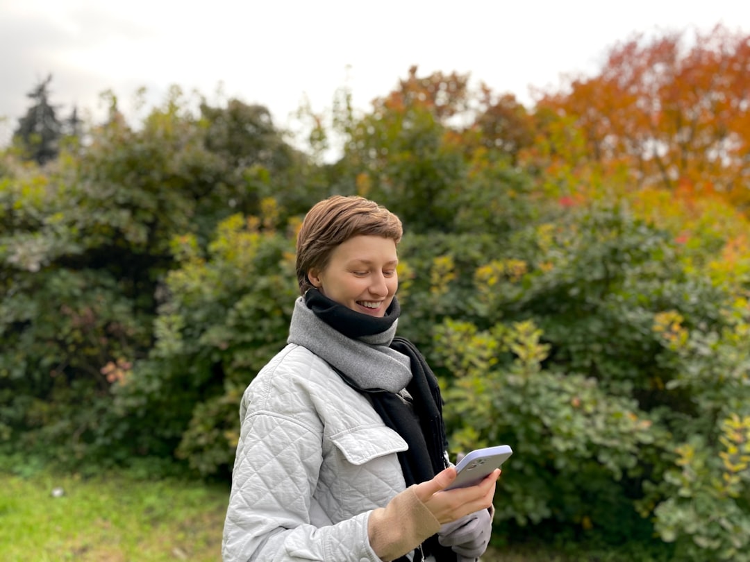 Person checking a smartphone app while standing in a garden