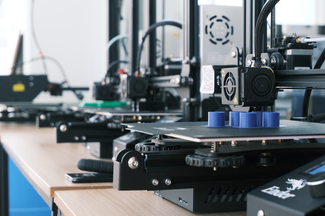 A row of compact 3D printers running on a work desk