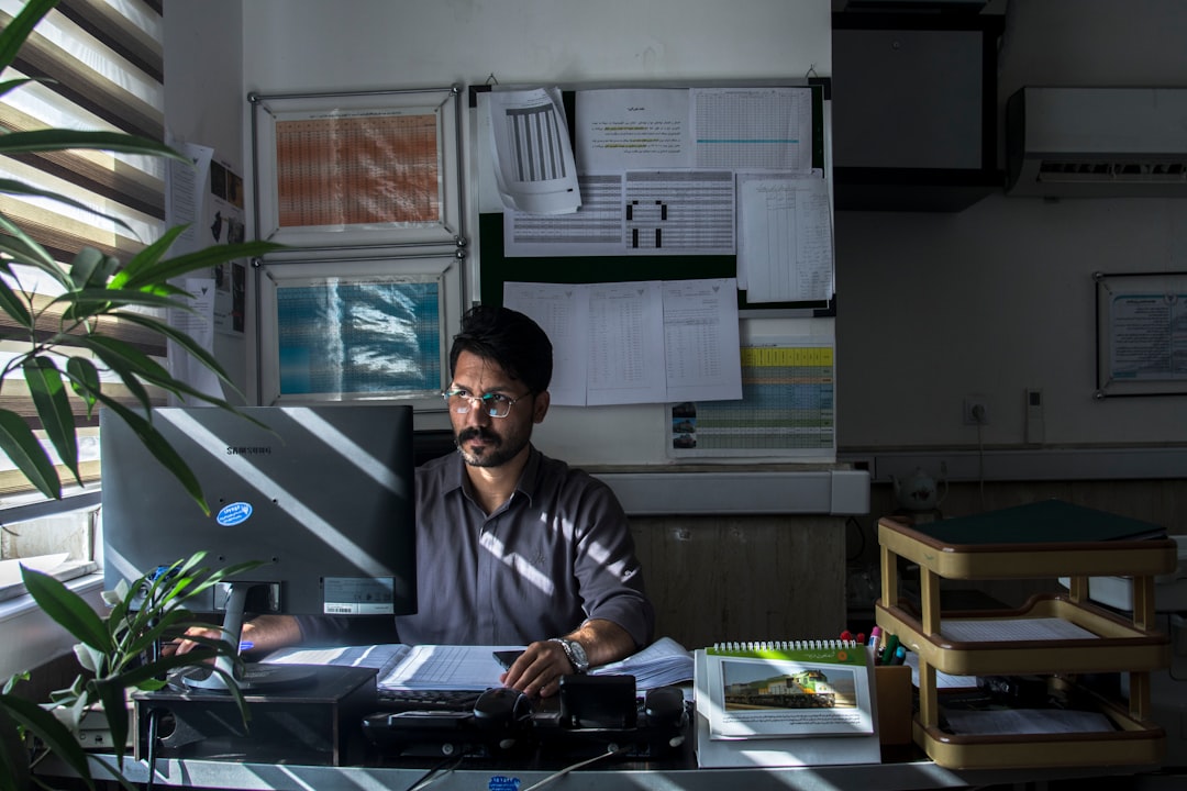 Man working at a desk covered in printed documents
