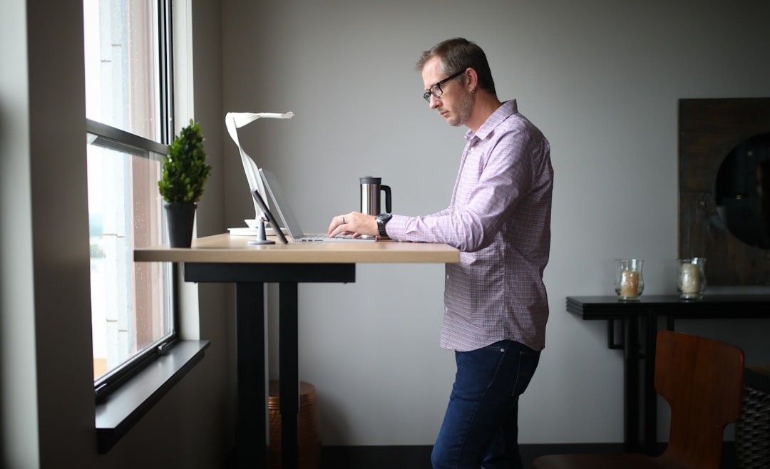 Office worker taking a stretch break beside a standing desk