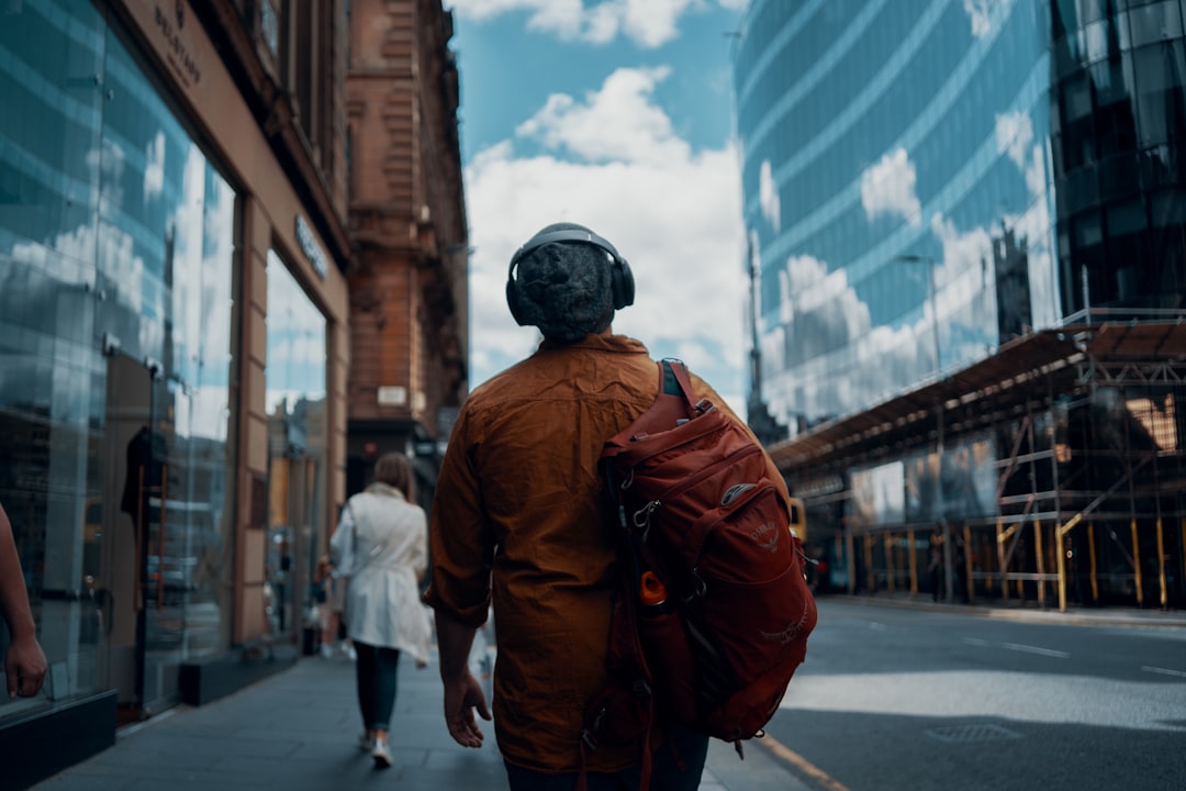 Person wearing wireless earbuds while commuting in the city