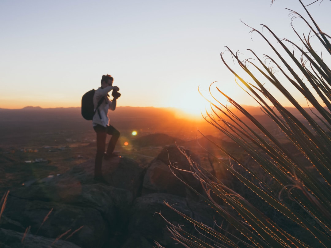 Travel filmmaker shooting handheld at sunset
