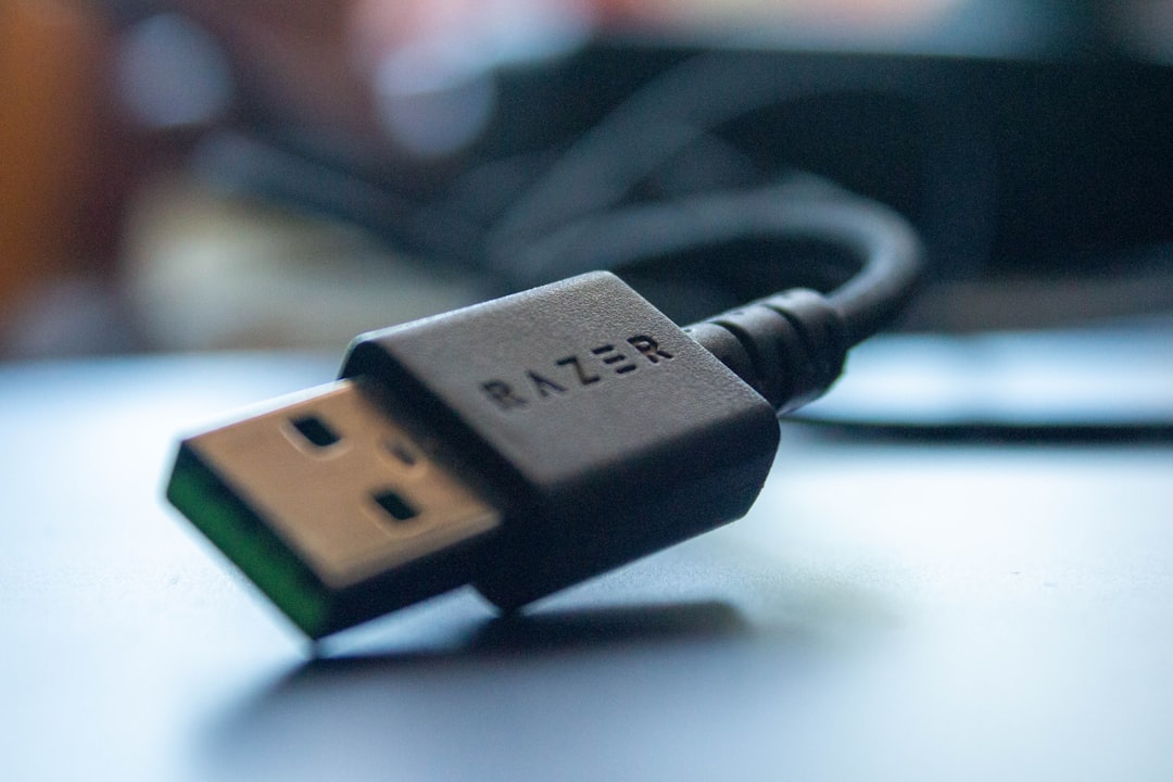 A metal USB security key resting beside a laptop