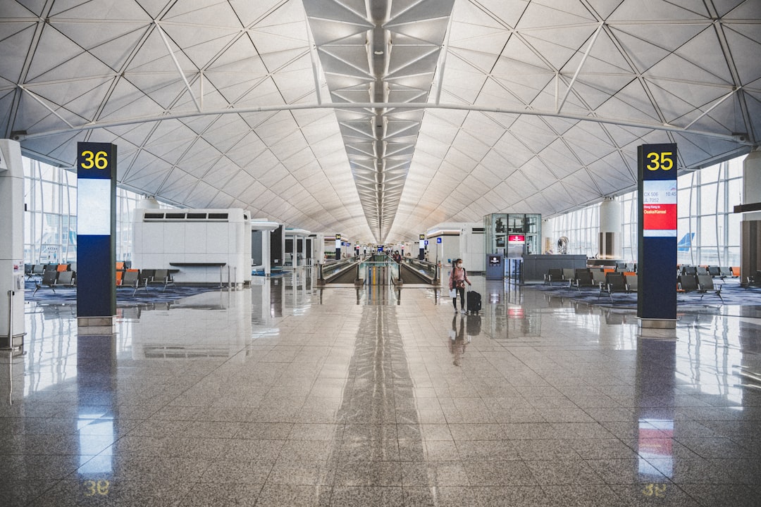 Traveler walking through a modern airport terminal with luggage