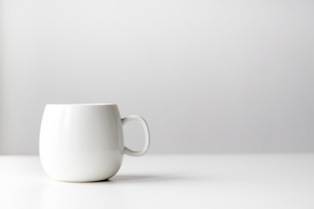 Coffee mug on desk with warmer device