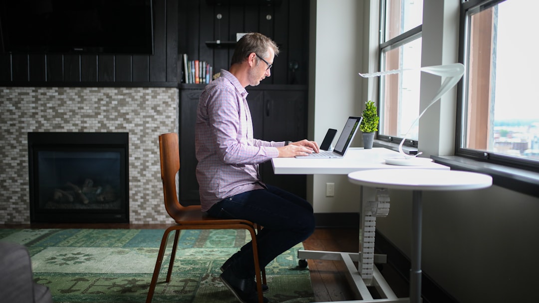 Office worker hunched over a laptop with poor posture