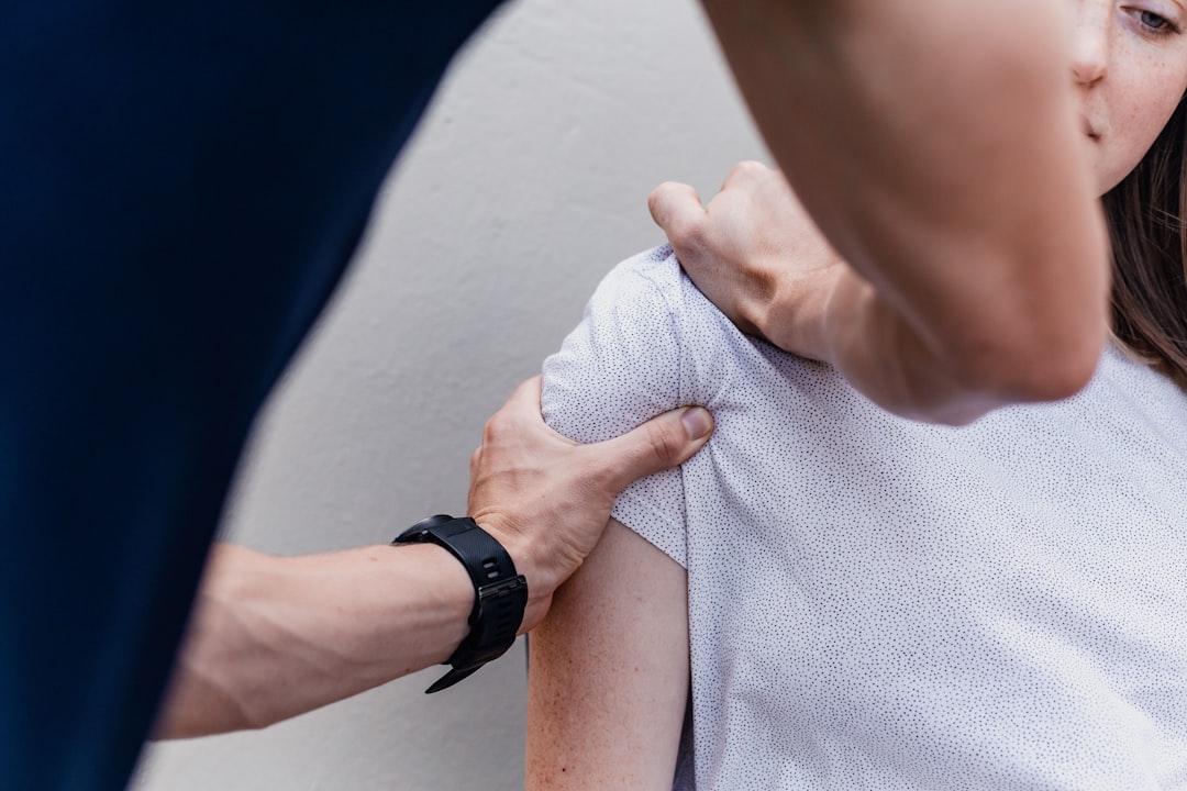 Percussive therapy being applied to a shoulder muscle