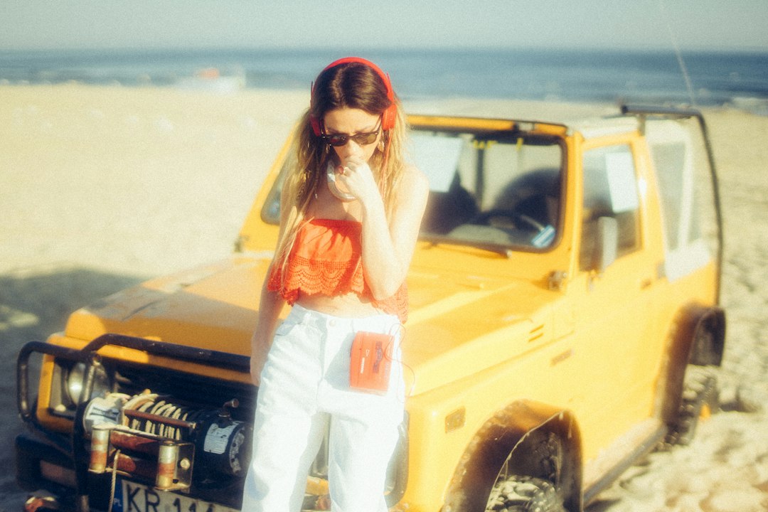 Woman wearing sunglasses listening to music outdoors