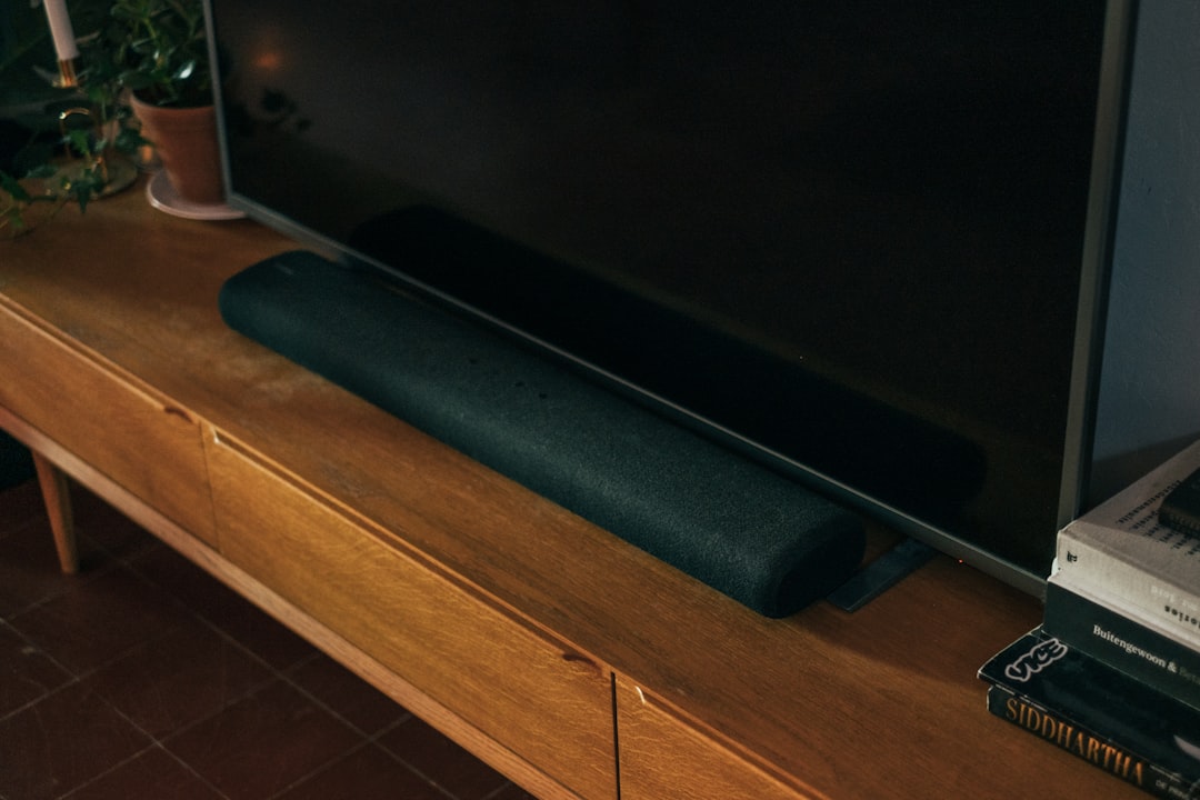 Soundbar mounted beneath a television on a media console