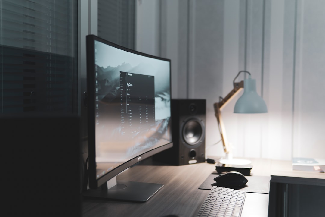 A large curved monitor glowing on a dim desk setup