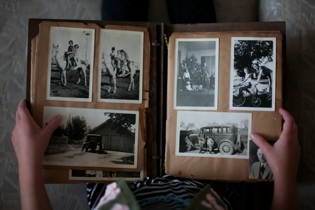 Hands holding an open photo album with old photographs
