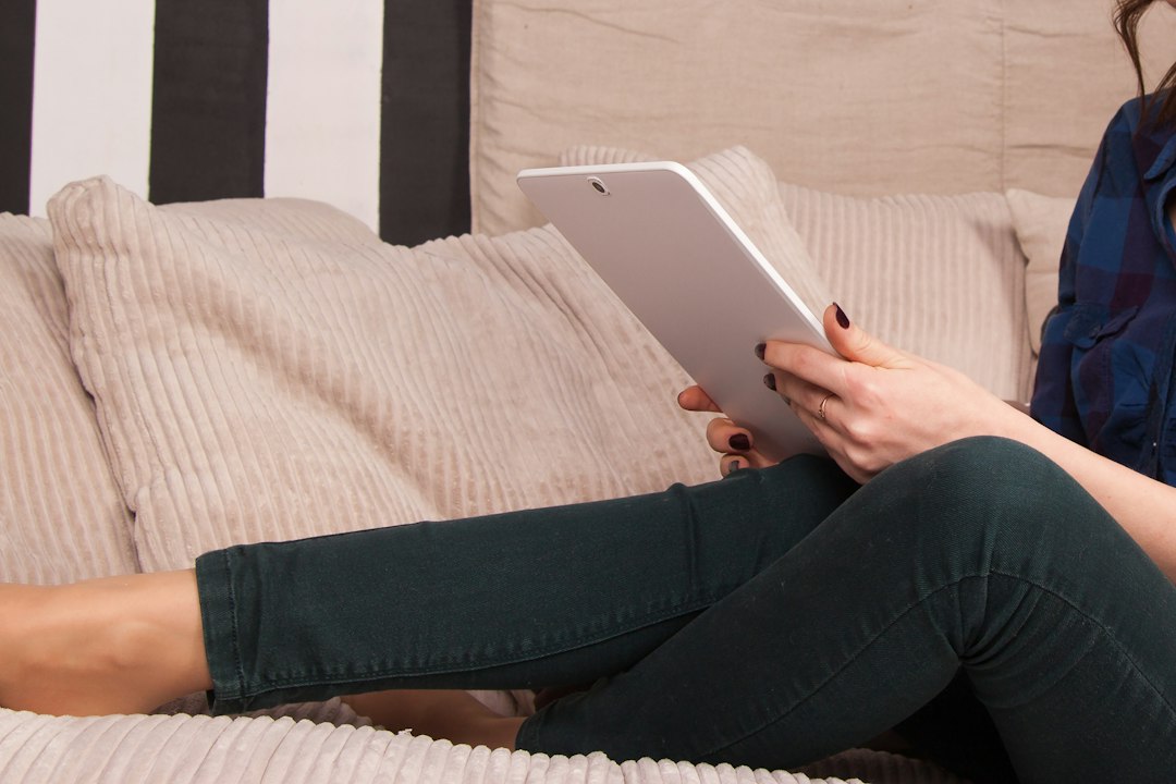 Reader relaxing on a couch with a lightweight tablet-style e-reader