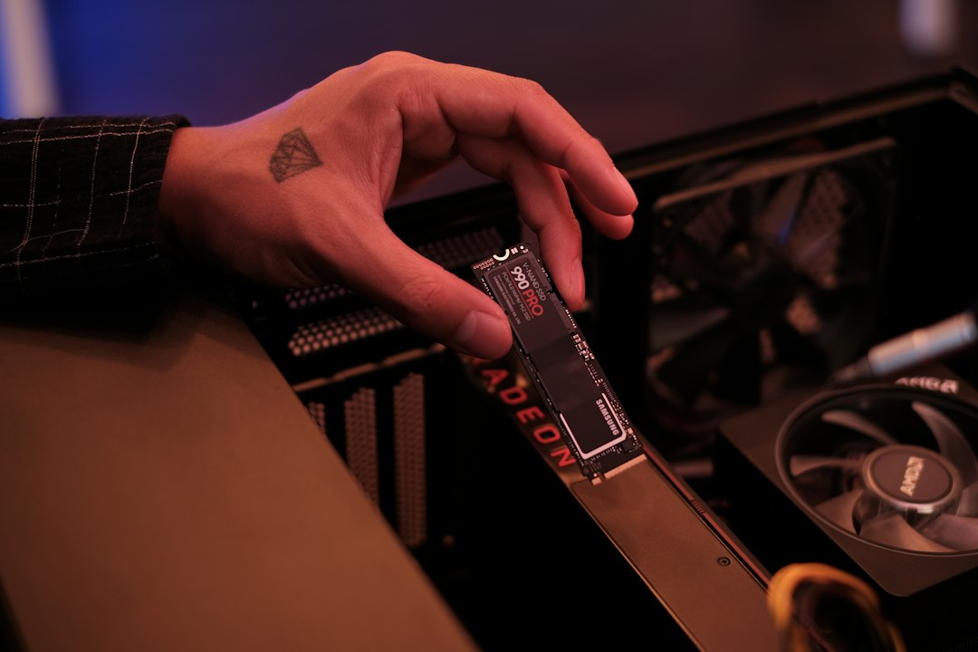 A Samsung 990 PRO M.2 NVMe SSD held next to a motherboard