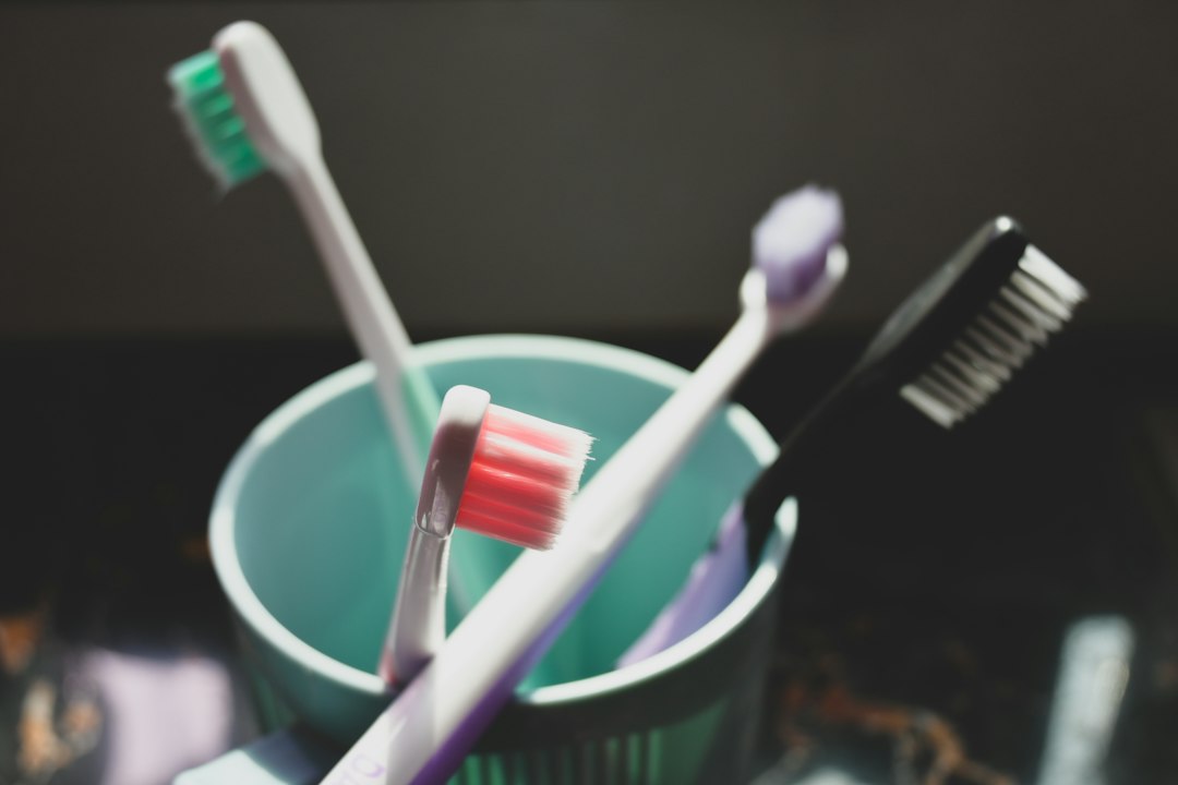 Multiple toothbrushes with colorful bristles in a holder