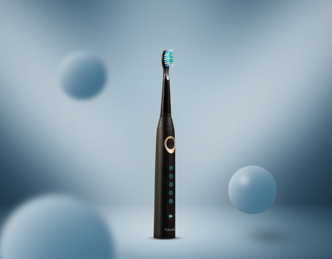 Black electric toothbrush standing upright on a counter