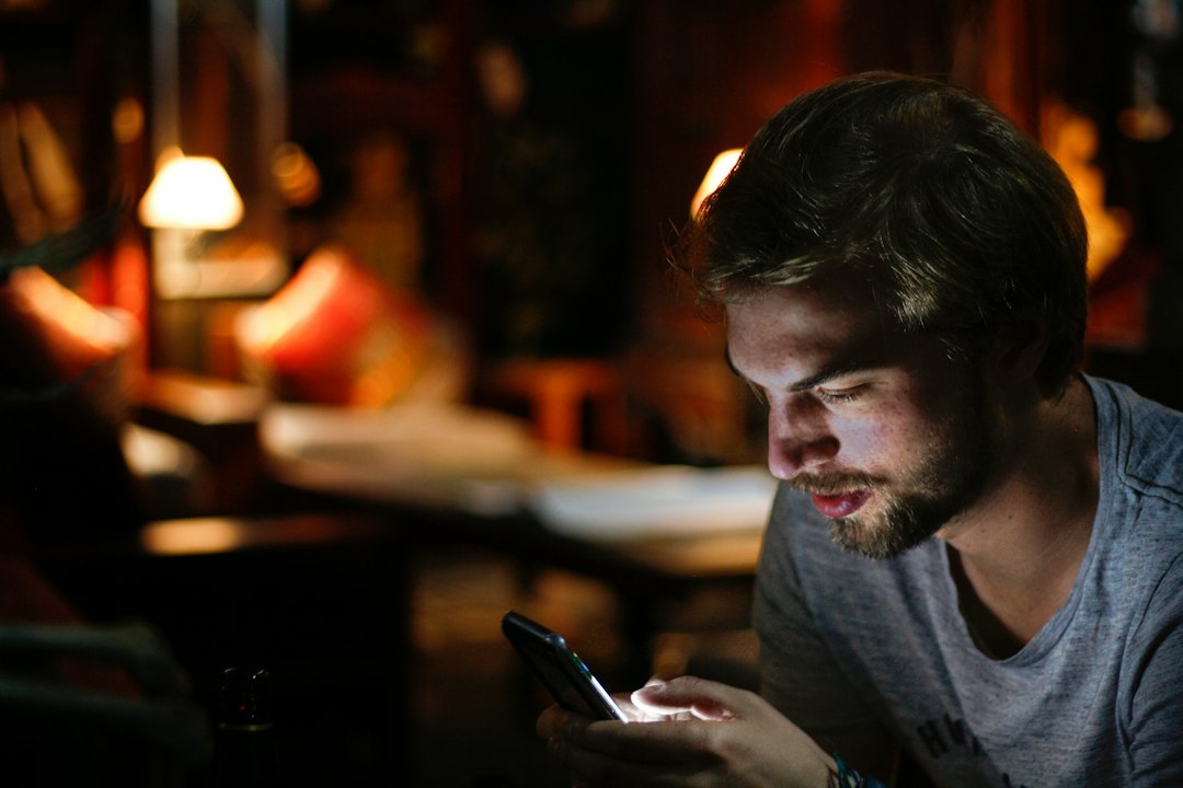 Man checking his smartphone app indoors in the evening