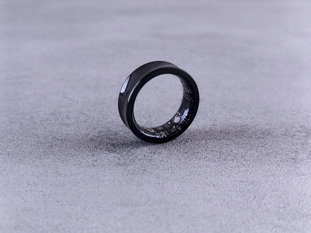 Black smart ring standing on a gray surface