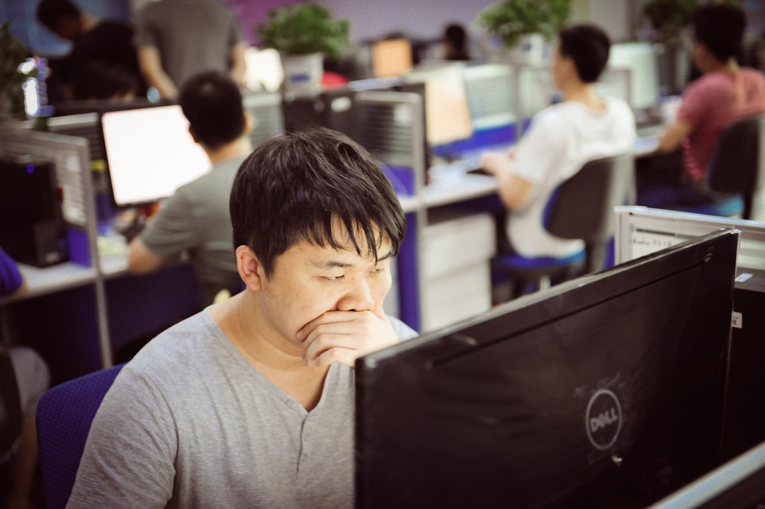 Tired office worker resting his head while staring at a monitor