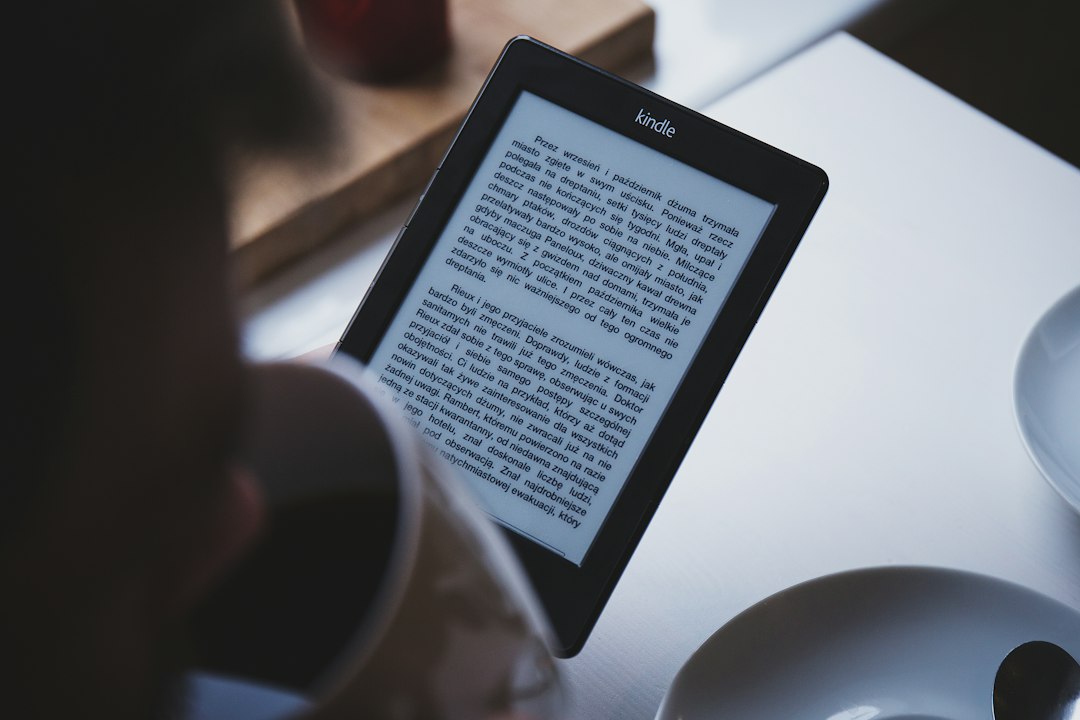 Hand holding an e-reader displaying a page of text