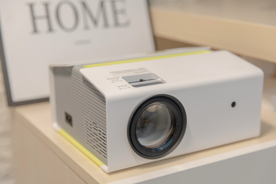 Compact projector set up on a table in a dim room