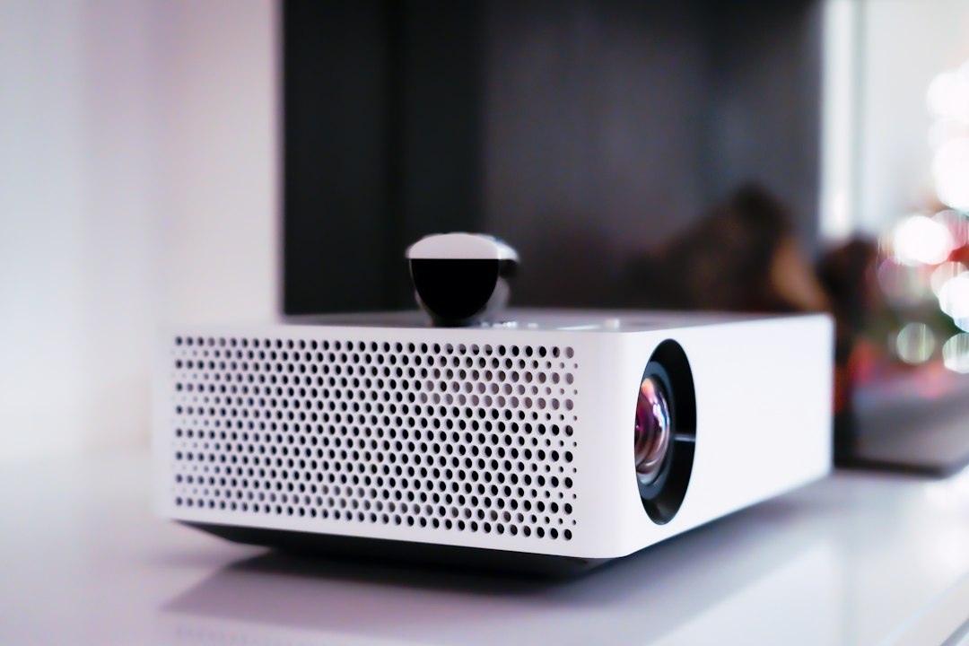A compact white portable projector resting on a table