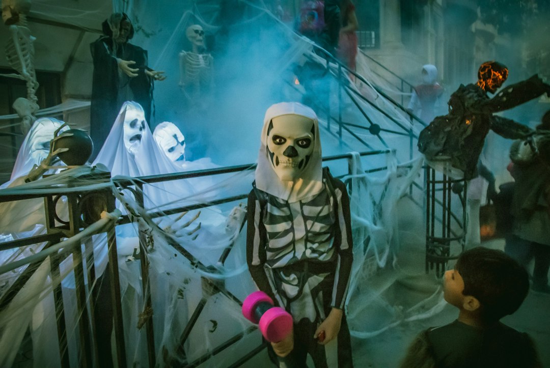 Children in skeleton and ghost costumes out on Halloween night
