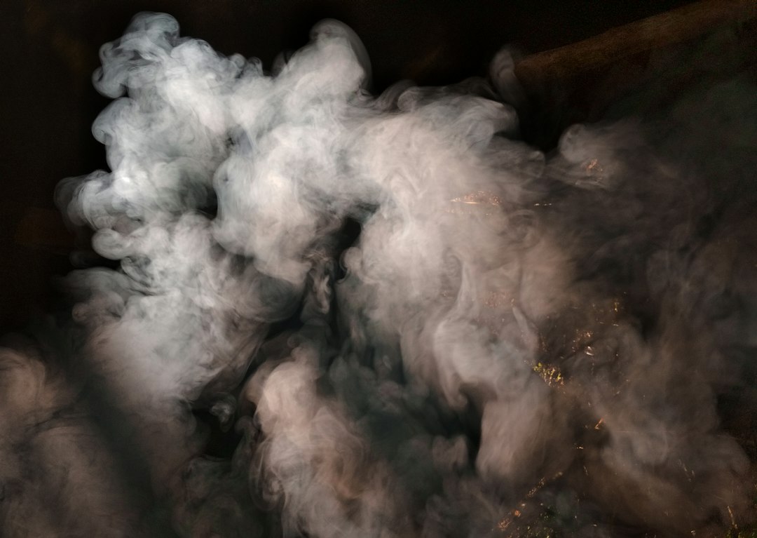 Thick fog rolling across a yard at night
