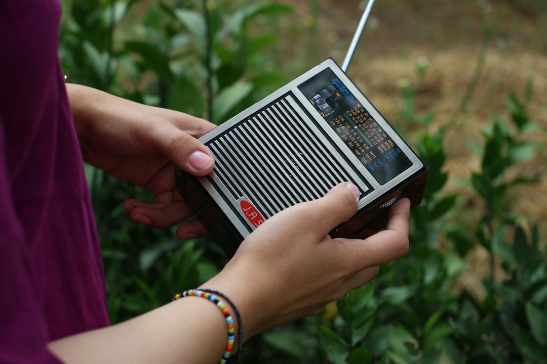 Handheld emergency weather radio held outdoors