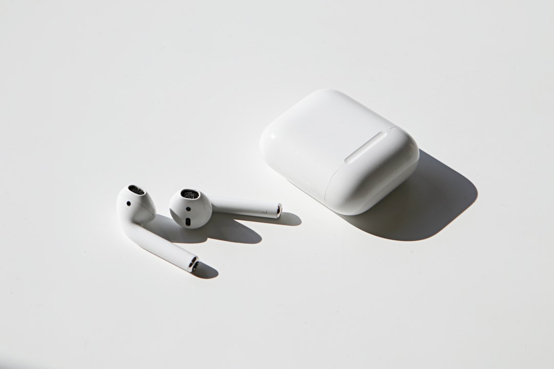 White wireless earbuds next to their charging case