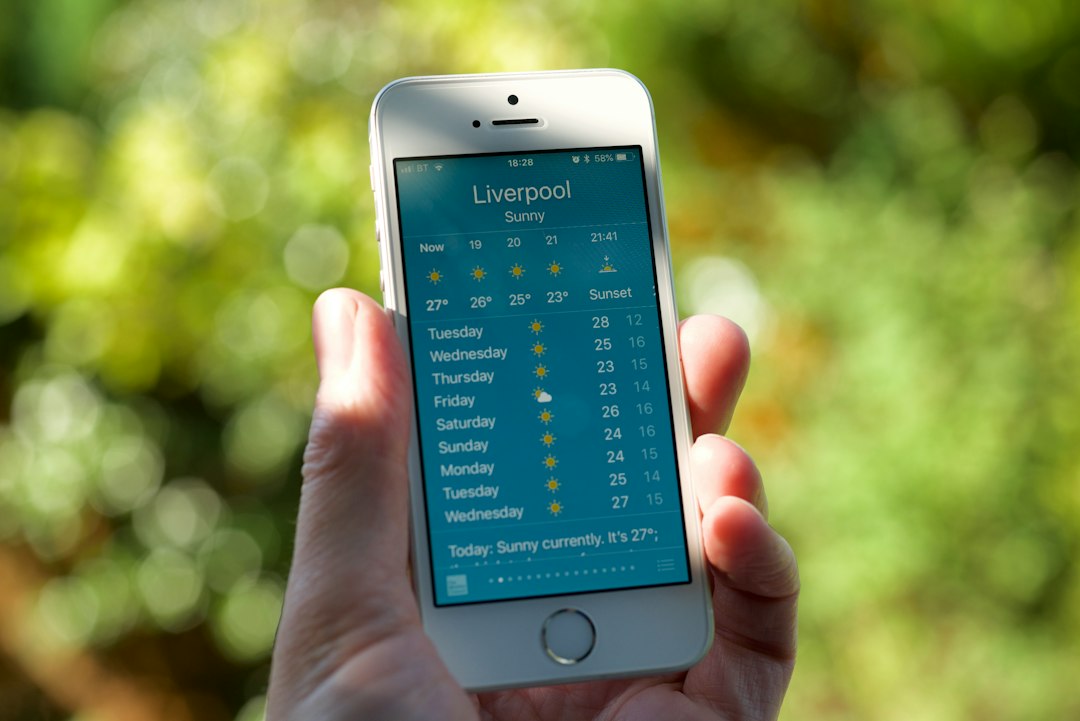 Phone in hand showing a weather forecast app