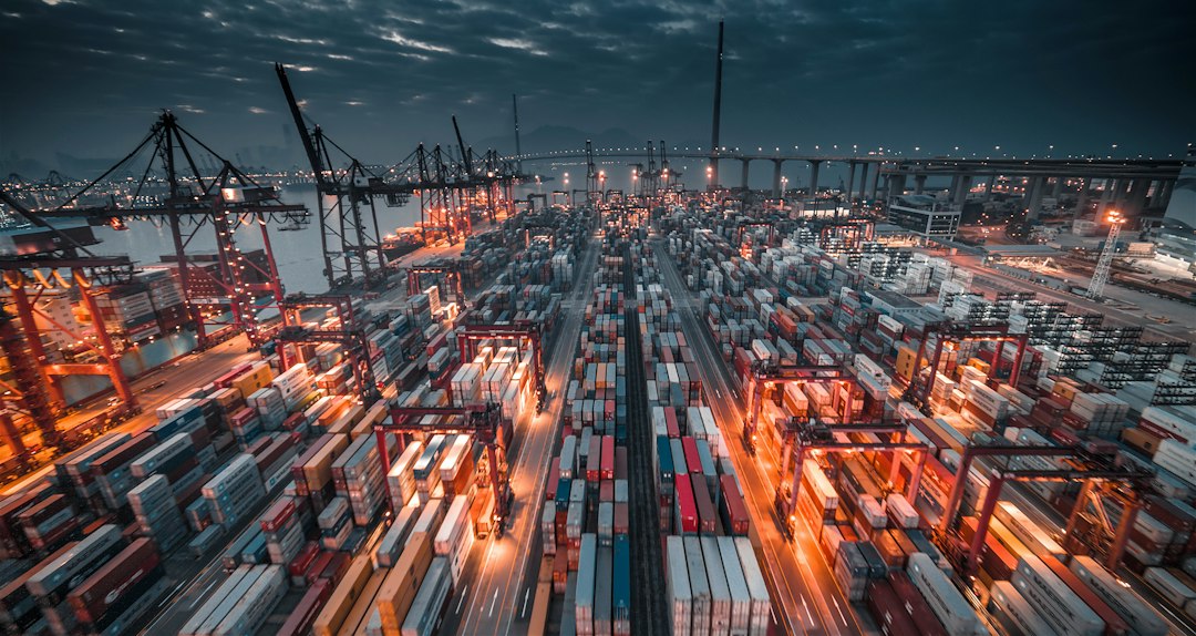 Aerial night view of a shipping port with stacked cargo containers