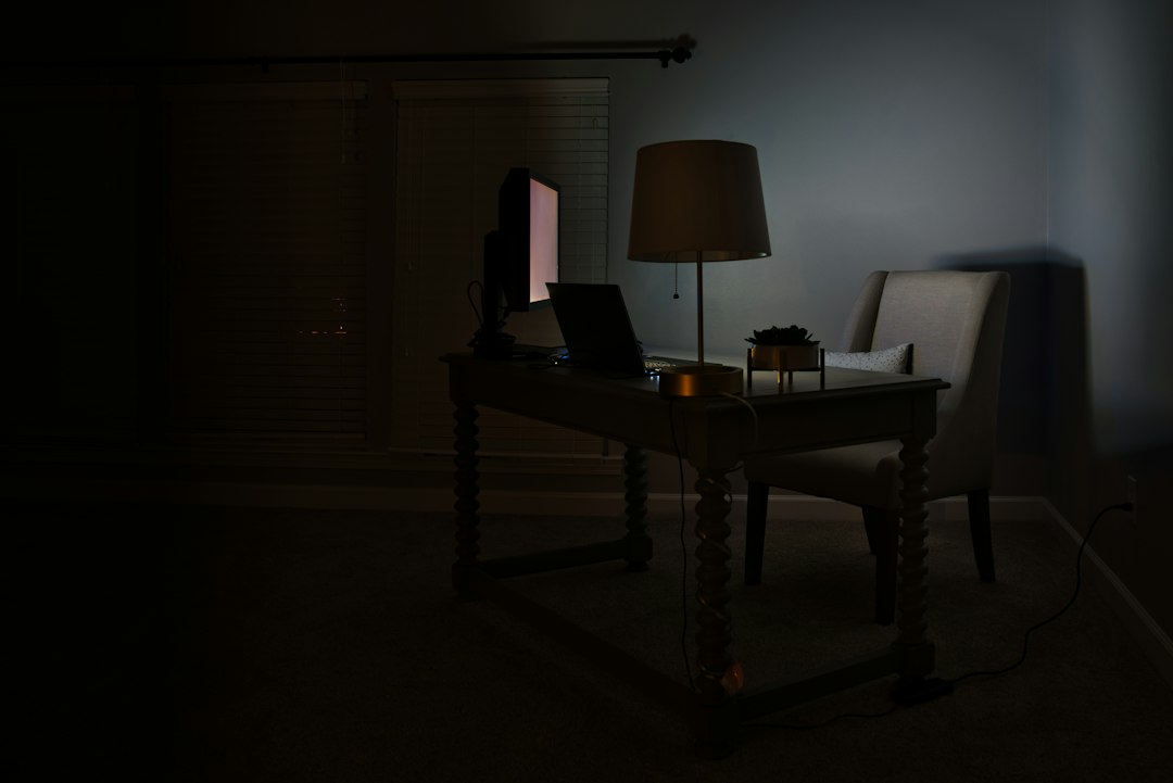 Desk with lamp glow in a dark room
