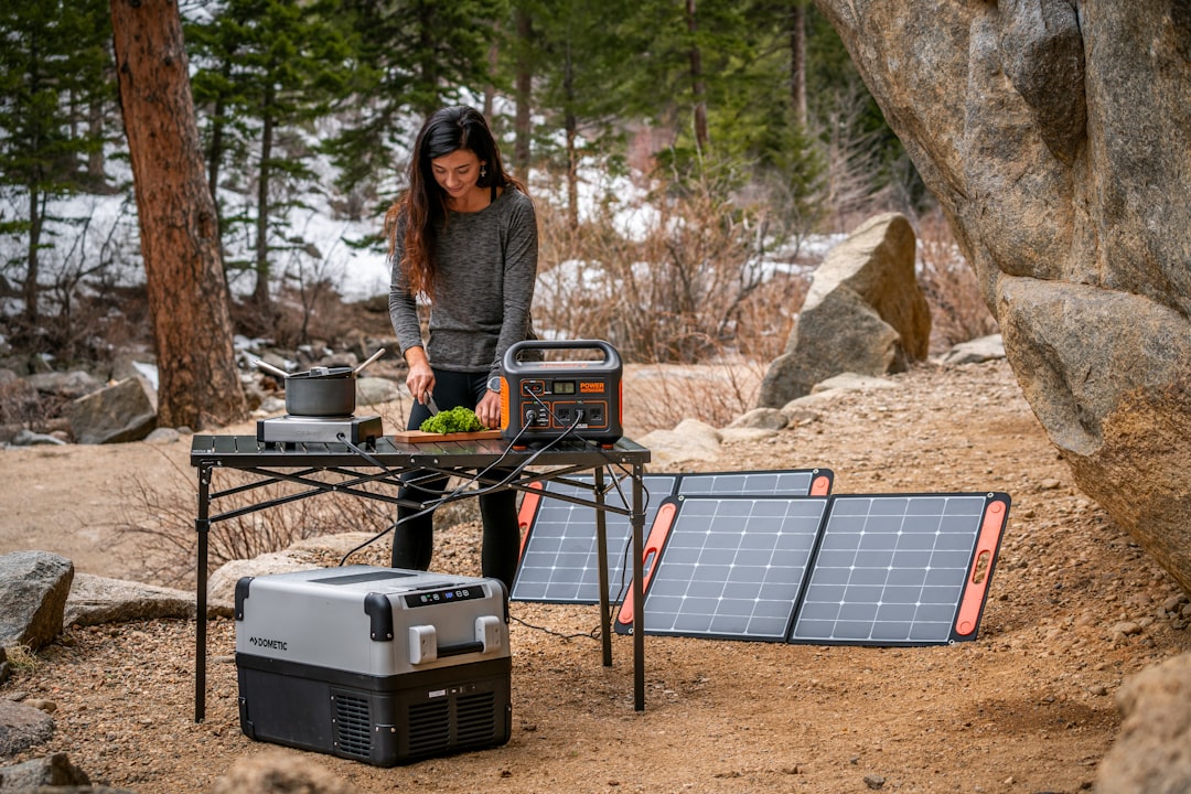 Portable power station connected to solar panels at a campsite
