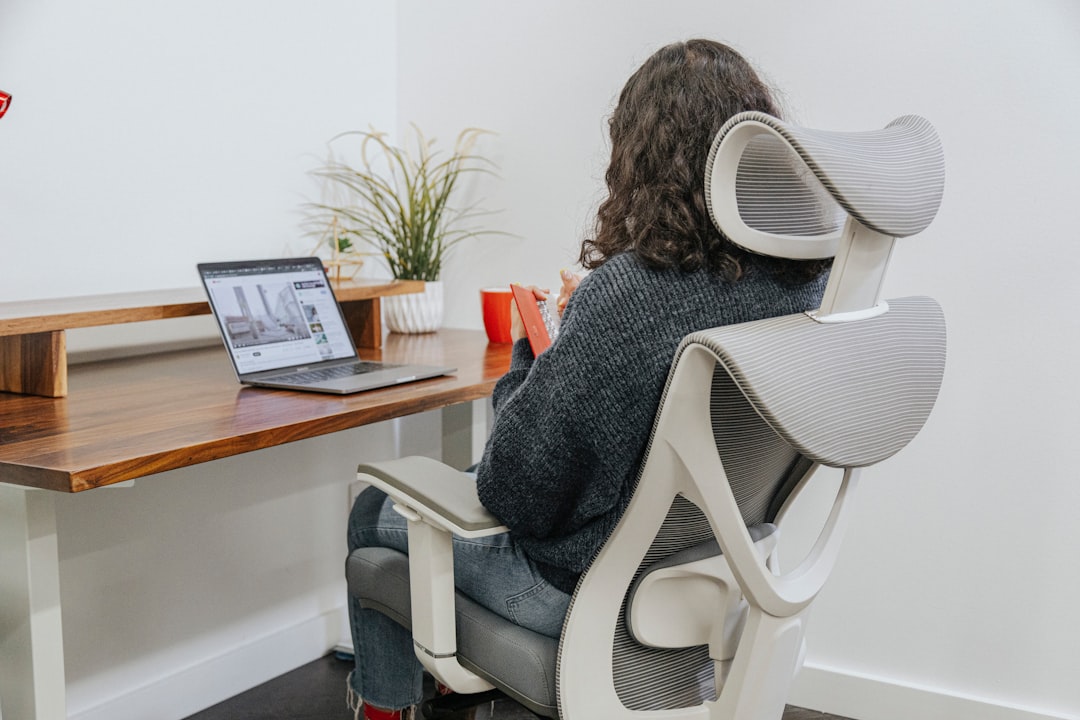 Person seated with good posture in an ergonomic mesh chair