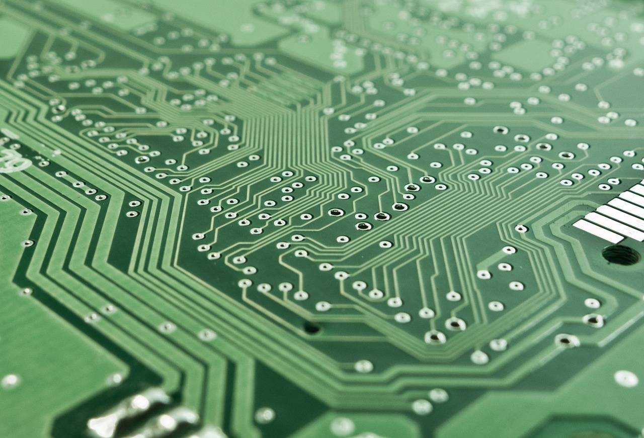 Green circuit board traces in close-up, the kind of dense layout packed into a palm-sized mini PC